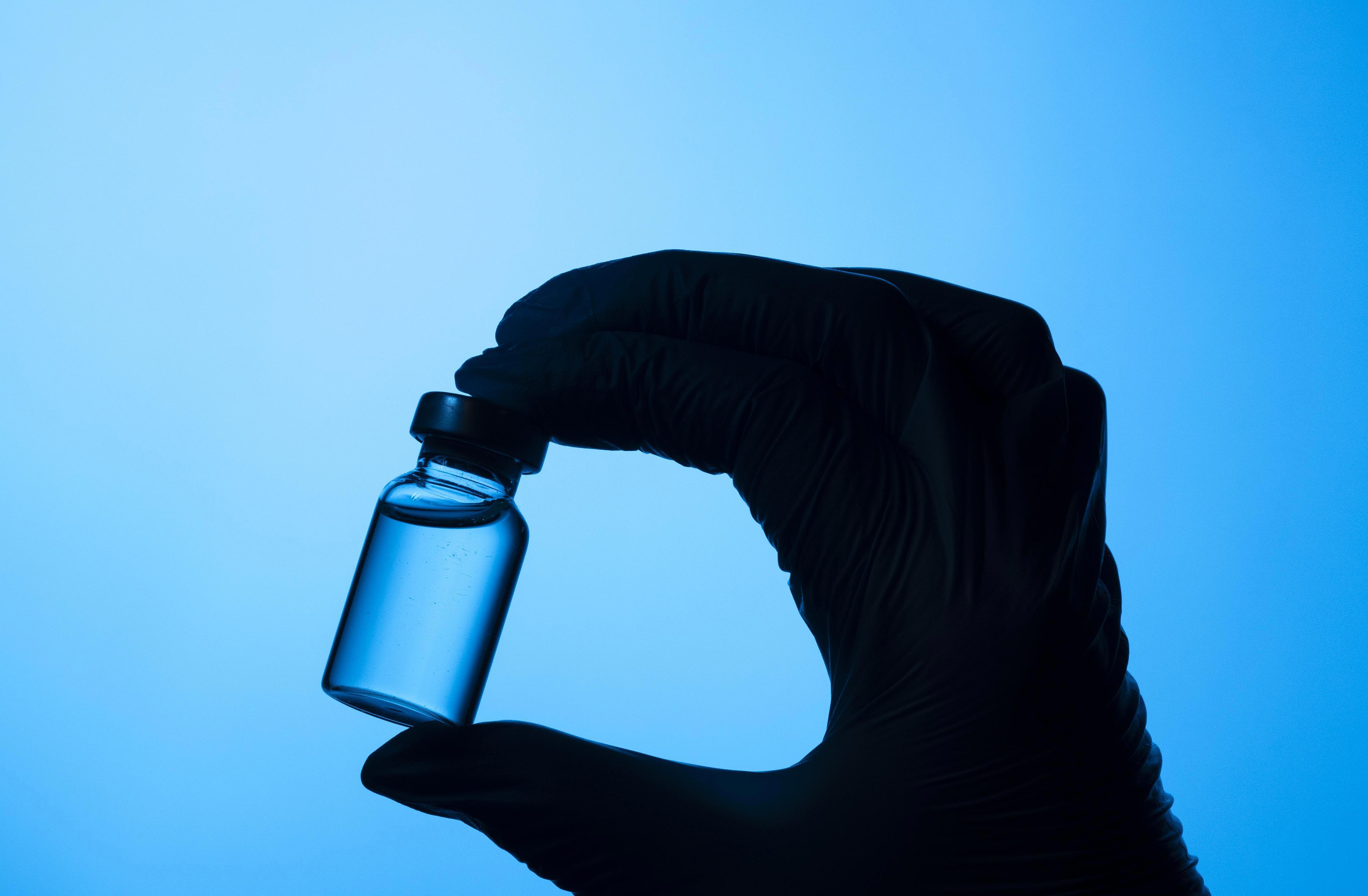 Hands With Protective Glove Holding Covid Vaccine