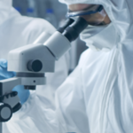 Lab technician looks into microscope